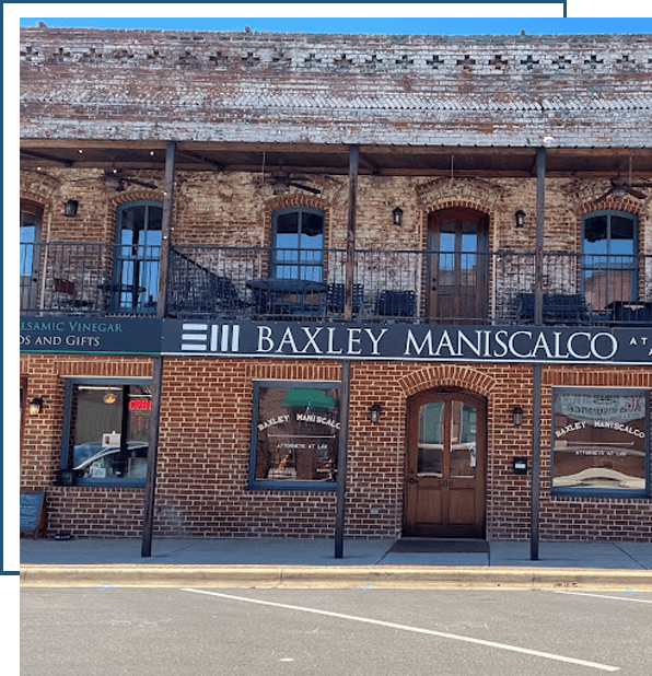 The front of the Baxley Maniscalco, LLP building is seen during the day time. The Baxley Maniscalco logo hangs above the main entrance.