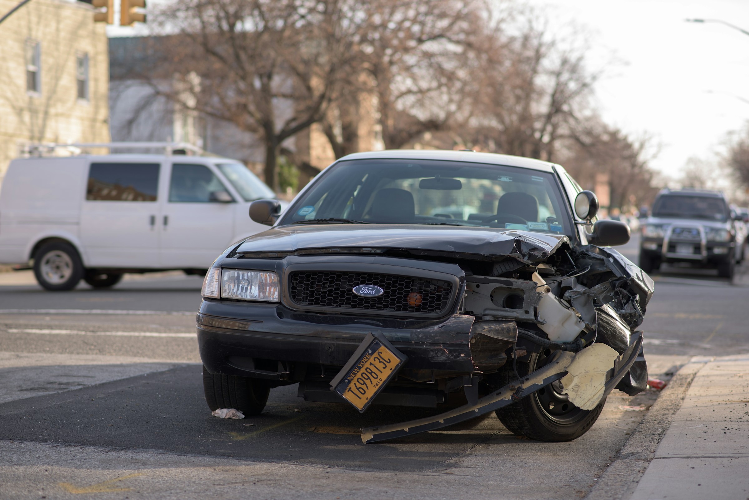 A car wreck sits in the middle of a road.